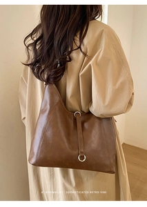Détail du sac hobo marron foncé en cuir ciré vintage avec boucles argentées et sangles