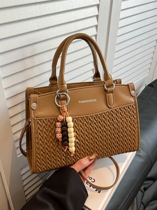 Brown woven patchwork tote handbag with top handles and a decorative bead tassel