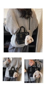 Détail du sac seau noir en cuir PU mat avec lettrage doré et breloque lapin mignon