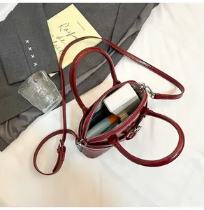Close-up of a burgundy leather handbag showing the zipper opening and spacious interior