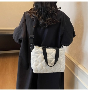 Détail du cabas matelassé blanc avec broderie florale et bandoulière noire contrastante