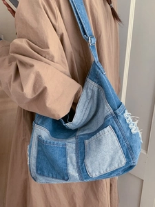 Denim patchwork tote bag with large capacity and frayed edges shown on a model