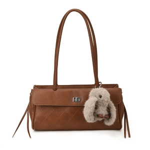 Detail of dark brown quilted tote bag with silver turn-lock and plush bunny charm accessory