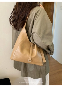 Chic tan faux leather tote bag with silver ring detail worn with a trench coat