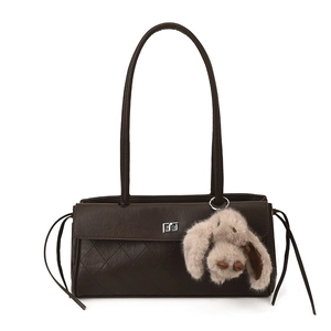 Detail of dark brown quilted tote bag featuring silver square lock and cute bunny pendant