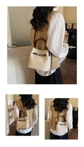 Detail of cream white leather bucket bag with brown handles and lychee texture