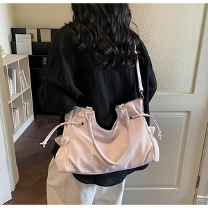 Detail view of large soft leather tote bag in dusty pink with drawstring pockets