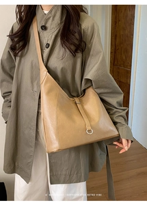 Close-up of minimalist retro tote bag in khaki PU leather with metal ring detail