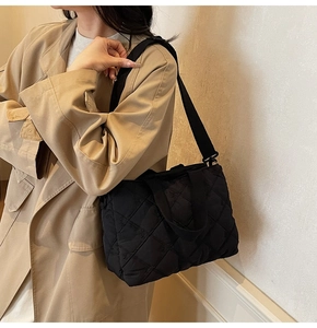 Détail du sac cabas matelassé noir avec motif à losanges et texture rembourrée douce