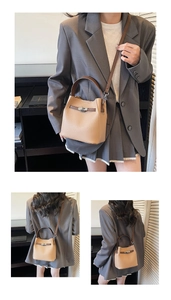 Detail of lychee textured leather bucket bag with silver lock and contrasting brown handles
