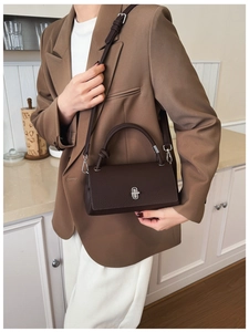 Detail of dark brown lychee leather crossbody bag with silver rotating metal lock