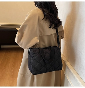 Détail de la texture matelassée noire et du motif à losanges sur le sac fourre-tout