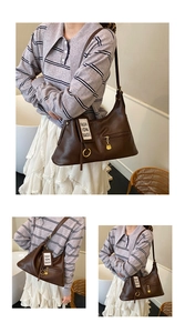 Detail of brown PU leather tote bag with gold ring hardware and exterior zipper pocket