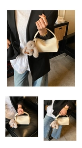 Detail der cremeweißen Boston Bag mit Litschistruktur und einem Plüsch-Hasen-Anhänger