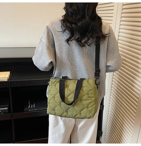 Détail du sac fourre-tout matelassé vert herbe avec bretelles noires et broderie菱格
