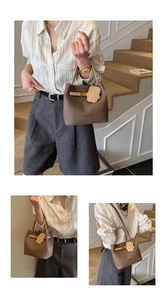 Gros plan du sac seau en cuir marron grainé avec boucle en métal et breloque ourson