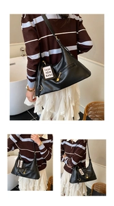 Detail view of a black leather hobo bag with gold hardware and fashion tag shown on shoulder