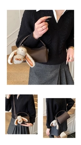 Detail der braunen Boston-Tasche aus strukturiertem Leder mit flauschigem Hasenanhänger