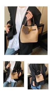 Détail du sac seau abricot avec texture litchi et breloque ours dans un décor urbain