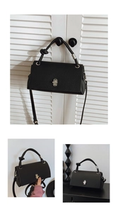 Detail view of black lychee grain leather handbag with silver twist lock and knot handle