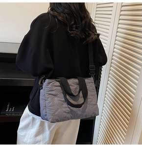 Détail du sac cabas gris matelassé avec broderie de nœud et bandoulière en nylon noir