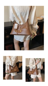 Detail of vintage brown leather tote bag with gold zippers and metal ring hardware