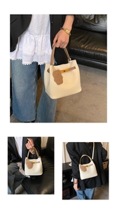 Détails du sac seau blanc crème avec poignées brunes et pendentif ours