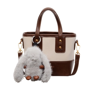 Borsa a secchiello bicolore beige e marrone con tracolla regolabile e charm coniglietto
