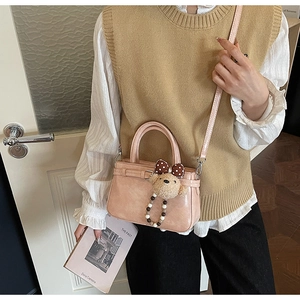 Detail der hellrosa Beuteltasche mit Plüschbärenanhänger und verstellbarem Schultergurt