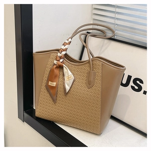 Detailed woven texture of a brown tote bag featuring a decorative silk scarf on handle