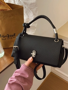 Black pebbled leather crossbody bag with silver twist lock and knotted handle detail