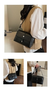 Détail d'un sac bandoulière noir avec boucle argentée et sangle réglable en cuir lisse