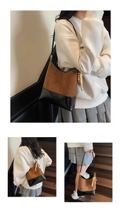 Detail of vintage tote bag showing brown suede, black leather panels and wood bead tassel