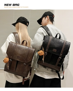 Detail of retro leather backpacks showing vintage buckle closure and bear charm accessory