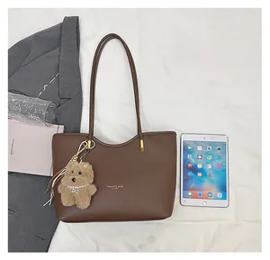 Brown litchi leather tote bag shown with an iPad to demonstrate its spacious capacity