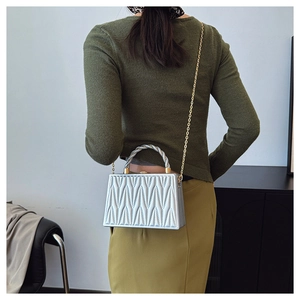 Pochette da sera argento con trapuntatura a V e tracolla a catena indossata a spalla