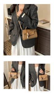 Brown leather baguette bag with woven panel detail and stylish wooden bead charm