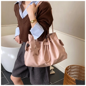 Detail of pink large-capacity tote bag with star charm and soft pleated leather texture