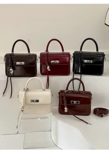 Fünf schicke Handtaschen in verschiedenen Farben mit Metalldrehverschluss und Quasten