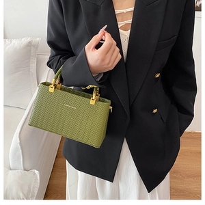 Detail of green woven shoulder bag featuring gold buckle and Fashion & Bags gold text