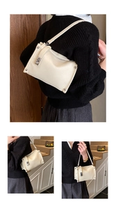 Detail view of cream white pebble leather handbag with silver twist lock and strap