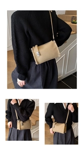 Detail of khaki pebbled leather shoulder bag featuring vintage metal buckle and rivet edges