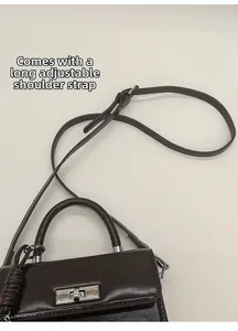 Detailansicht der braunen PU-Ledertasche mit Metallschloss und verstellbarem Schultergurt