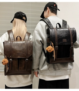 Detail of vintage faux leather backpacks in black and brown with bear charms
