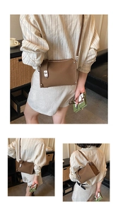 Detail of brown faux leather crossbody bag with silver buckle and stud hardware
