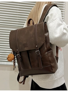 Close-up of vintage brown PU leather backpack featuring flap cover and teddy bear charm