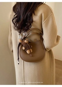 Brown lychee texture bucket bag with cute bear charm shown on a wool coat outfit