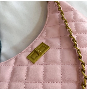 Détail du sac matelassé rose avec fermoir rectangulaire doré et bandoulière chaîne