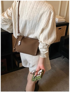Detail of a brown vintage leather shoulder bag with silver rivet studs and top zipper