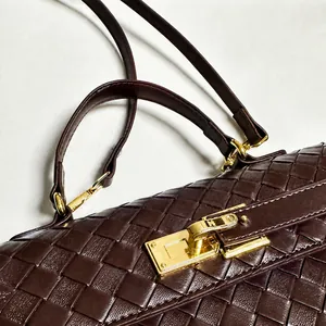 Dettaglio della borsa a tracolla in pelle intrecciata marrone con chiusura dorata